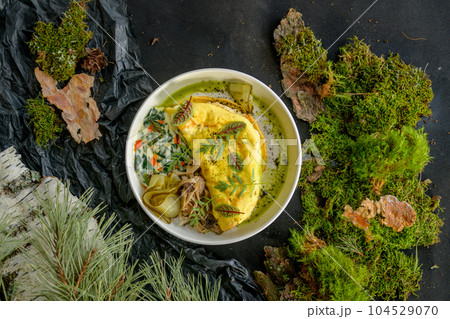 Omelette with cheese, mushrooms and herbs on a white plate Omelette with cheese, mushrooms and herbs on a white plate 104529070
