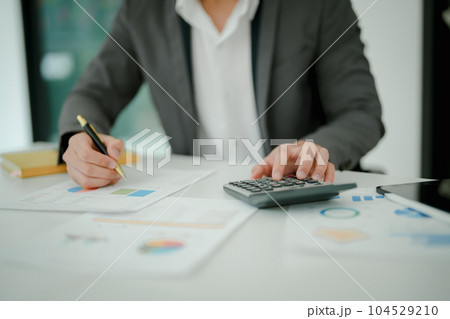 Young asian male work with financial papers at home count on calculator before paying taxes receipts online, planning budget glad to find chance for economy saving money, audit concepts 104529210