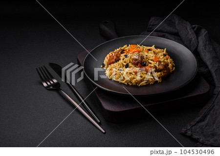 Delicious fresh pilaf with rice, carrots, meat, onions, spices and berries 104530496