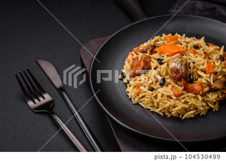 Delicious fresh pilaf with rice, carrots, meat, onions, spices and berries 104530499
