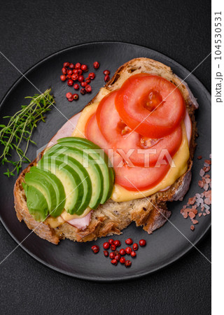 Delicious nutritious grilled toast with ham, cheese, tomatoes and avocado Delicious nutritious grilled toast with ham, cheese, tomatoes and avocado 104530531