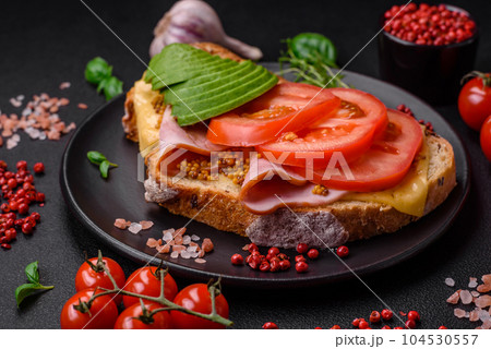 Delicious nutritious grilled toast with ham, cheese, tomatoes and avocado Delicious nutritious grilled toast with ham, cheese, tomatoes and avocado 104530557