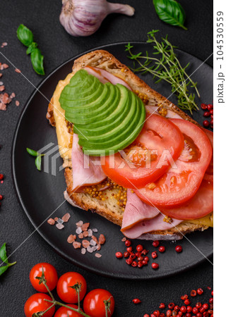 Delicious nutritious grilled toast with ham, cheese, tomatoes and avocado Delicious nutritious grilled toast with ham, cheese, tomatoes and avocado 104530559