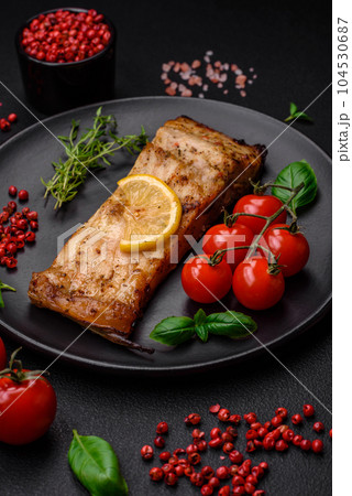 Slice of delicious baked fish with salt, spices and herbs on a ceramic plate Slice of delicious baked fish with salt, spices and herbs on a ceramic plate 104530687