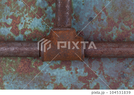 Rusty valve pipes on rusty metal wall Rusty valve pipes on rusty metal wall 104531839