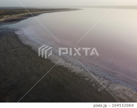 a serene lake with a muddy shore, surrounded by a tranquil atmosphere 104532069