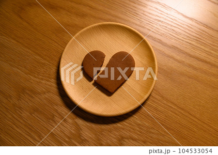 木の皿の上に割れたハートのクッキー　失恋　恋愛　broken heart　ハートブレイク　周辺減光無 104533054