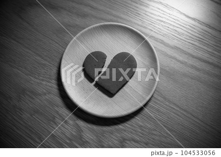 木の皿の上に割れたハートのクッキー　失恋　恋愛　broken heart　ハートブレイク　モノクロ 104533056