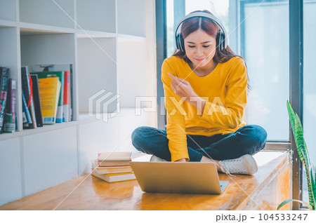 young student wearing headphones studies online, distance learning, and keeps up to date on the global coronavirus pandemic. young student wearing headphones studies online, distance learning, and keeps up to date on the global coronavirus pandemic. 104533247