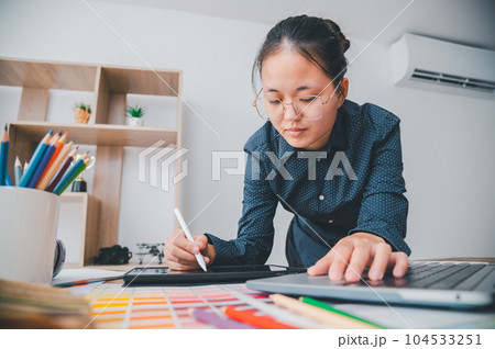 Graphic designer architects who work with laptops and color comparison tables for design work.. 104533251