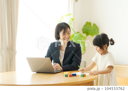 自宅で働くママと女の子の写真 104533762