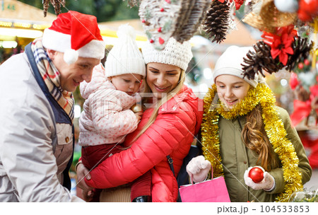 Parents with daughters choosing Christmas toys Parents with daughters choosing Christmas toys 104533853