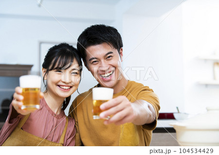ビールで乾杯する若い夫婦 ビールで乾杯する若い夫婦 104534429