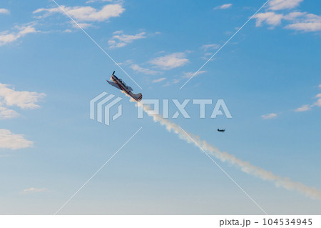 Light aircraft flying in blue sky and doing stunts 104534945