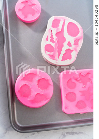 Making sea-shaped chocolates to decorate chocolate-dipped pretzels twists. 104540298