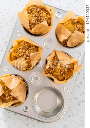 Freshly baked banana oatmeal muffins in a small muffin pan. Freshly baked banana oatmeal muffins in a small muffin pan. 104540336