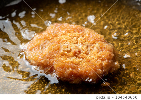 残った揚げ物(とんかつ)リメイク調理シーン。卵とじするためだし汁の入ったフライパンで煮る。 104540650