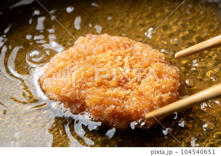 残った揚げ物(とんかつ)リメイク調理シーン。卵とじするためだし汁の入ったフライパンで煮る。 104540651