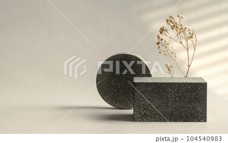 Minimal stone stage product display with sunlight from window and dry flower on cream color background 104540983