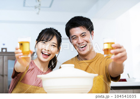 ビールで乾杯する若い夫婦 104541035