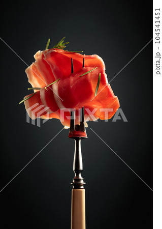 Sliced prosciutto with rosemary. Sliced prosciutto with rosemary. 104541451
