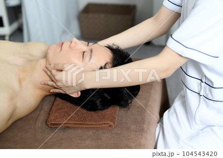 フェイシャルエステを受ける若い男性 フェイシャルエステを受ける若い男性 104543420