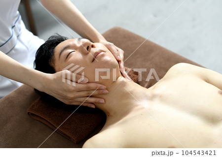 フェイシャルエステを受ける若い男性 フェイシャルエステを受ける若い男性 104543421