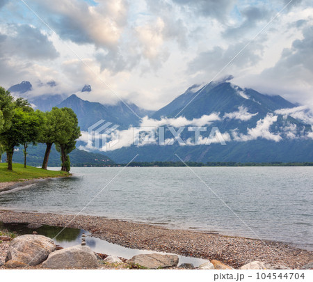 Lake Como (Italy) summer cloudy view with stony shore. 104544704