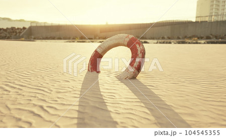 Lifebuoy on the city beach at sunset Lifebuoy on the city beach at sunset 104545355