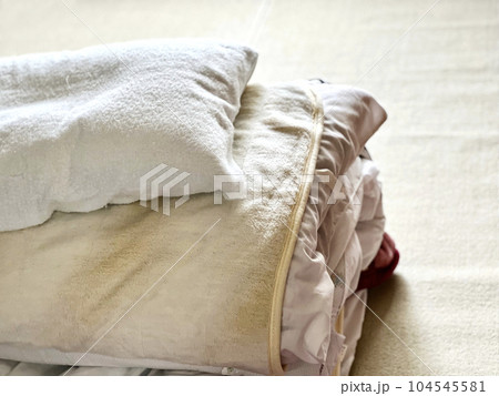 畳んだ布団と枕 104545581