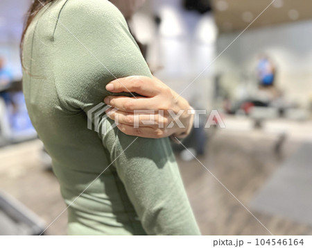フィットネスジムで二の腕をつかむ女性 104546164