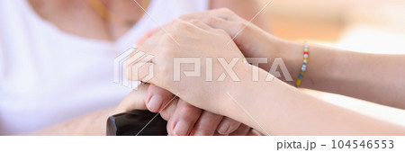 Young woman putting hands on granny hands, supporting gesture Young woman putting hands on granny hands, supporting gesture 104546553