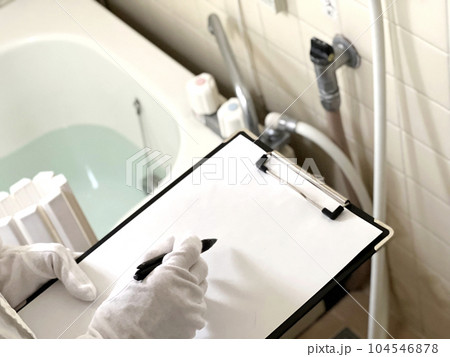 お風呂のガスコックを査定するクリップボードを持った白手袋の手元 104546878