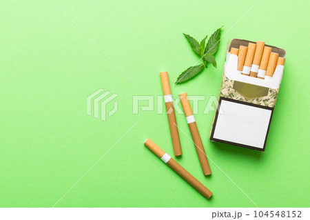 Pack of menthol cigarettes and fresh mint on colored table, Menthol cigarettes top view flat lay Pack of menthol cigarettes and fresh mint on colored table, Menthol cigarettes top view flat lay 104548152