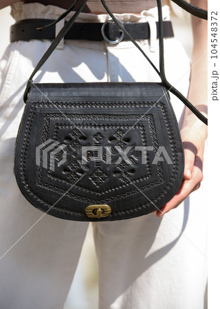 small black women's leather bag with a carved pattern. selective focus small black women's leather bag with a carved pattern. selective focus 104548372