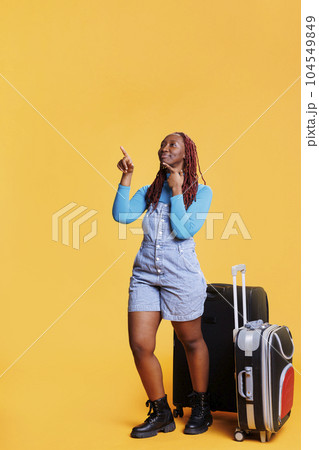 Tourist pointing at scenic route in town, having fun on citybreak vacation with luggage. Young person sightseeing and enjoying buildings architecture on holiday, urban adventure. Tourist pointing at scenic route in town, having fun on citybreak vacation with luggage. Young person sightseeing and enjoying buildings architecture on holiday, urban adventure. 104549849