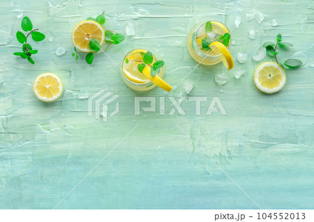 Lemonade with mint. Lemon water drink with ice. Two glasses and lemons Lemonade with mint. Lemon water drink with ice. Two glasses and lemons 104552013
