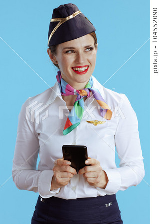 happy stylish female stewardess on blue using phone 104552090
