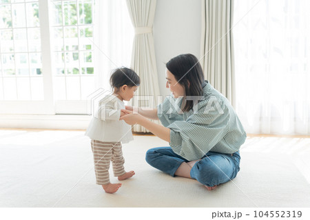 ママと手を繋いで歩く練習をする赤ちゃん(育児・子育て・つかまり立ち) ママと手を繋いで歩く練習をする赤ちゃん(育児・子育て・つかまり立ち) 104552319