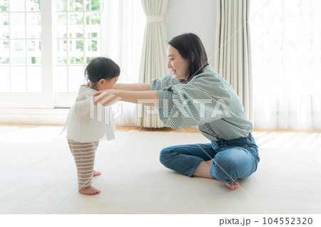 ママと手を繋いで歩く練習をする赤ちゃん（育児・子育て・つかまり立ち） 104552320