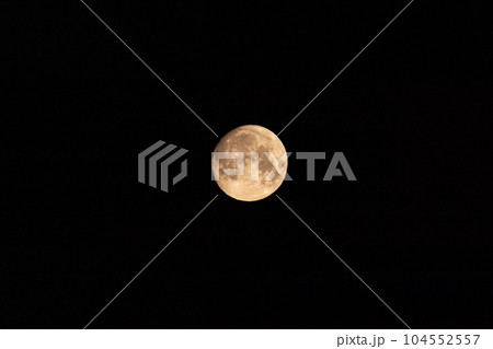 Bright light orange full moon on dark night sky Bright light orange full moon on dark night sky 104552557