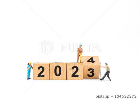 Miniature people , Worker team flips a wooden block with the number 2024 104552575