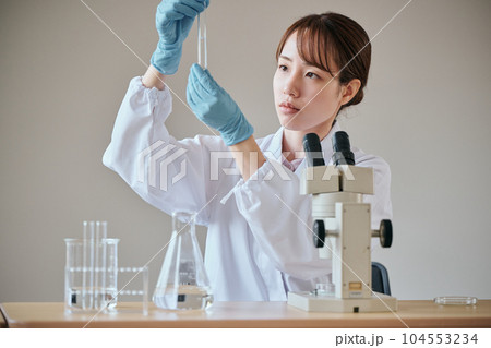 実験をする白衣の若い女性 実験をする白衣の若い女性 104553234