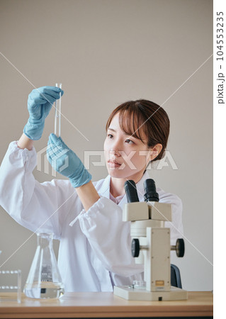 実験をする白衣の若い女性 実験をする白衣の若い女性 104553235