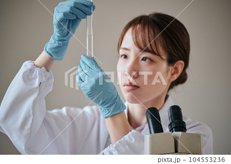実験をする白衣の若い女性 実験をする白衣の若い女性 104553236