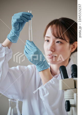 実験をする白衣の若い女性 実験をする白衣の若い女性 104553237
