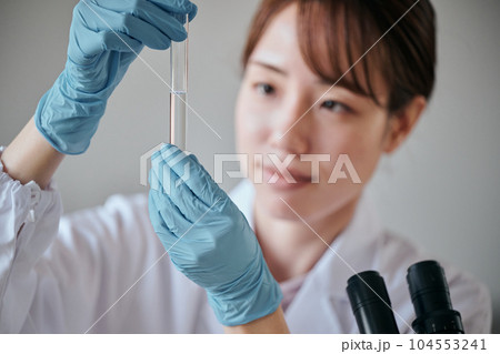 実験をする白衣の若い女性 実験をする白衣の若い女性 104553241