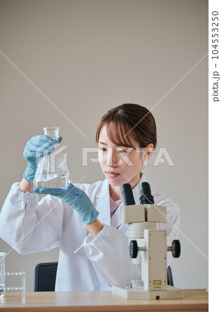 実験をする白衣の若い女性 実験をする白衣の若い女性 104553250