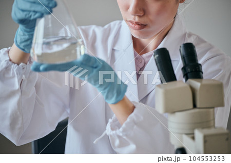 実験をする白衣の若い女性 104553253