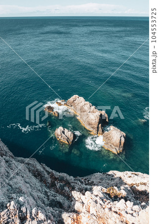 Rocky steep cliff look down, blue Ionian seascape Rocky steep cliff look down, blue Ionian seascape 104553725